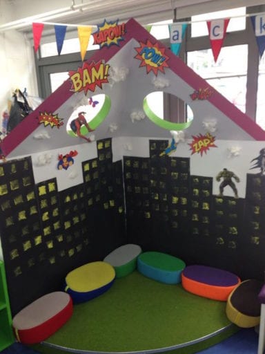 Book corner designed like a cityscape with superheroes flying in sky