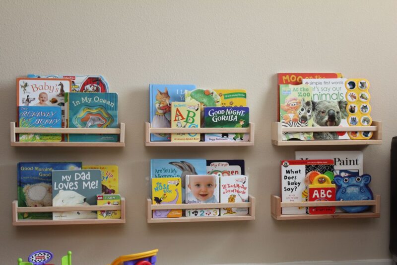 Several shelves are attached to the wall with books inside of them covers facing outward in this example of Ikea classroom.