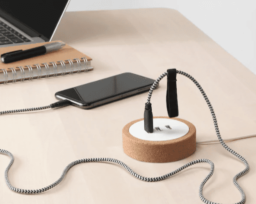 USB Charger A circular charger with USB outlets is shown with a computer and phone plugged into it.
