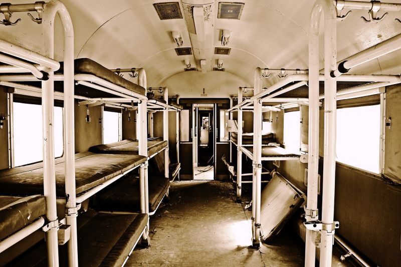 Picture Prompts: Abandoned Train Car Sepia-toned image of an old sleeper train car in disrepair