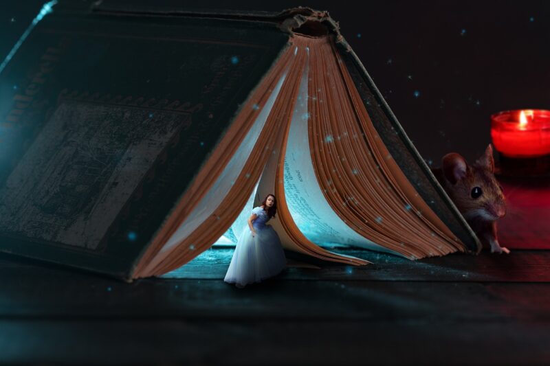 Picture Prompts: Out of the Book Woman dressed in a blue ball gown peering out of a book lit from inside, with a mouse nearby