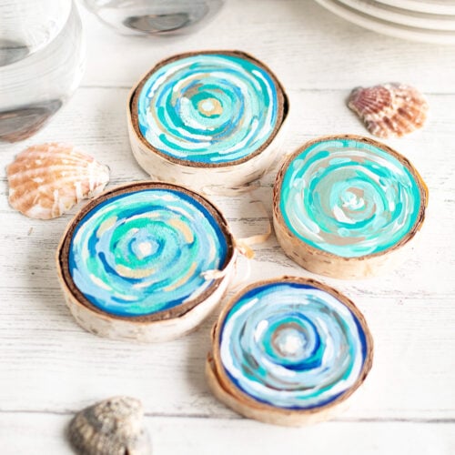 coastal-coasters Discs of wood painted with blue paint laid out on a table as an example of summer crafts for kids