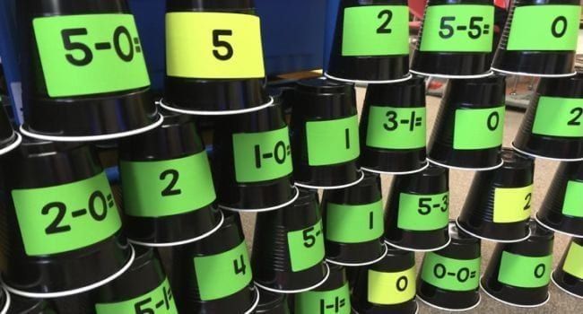 Dollar Store Hacks: Math Facts Cups Black plastic cups with math facts and answers stacked in rows