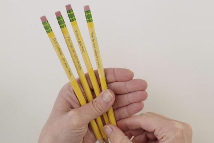 Dollar Store Hacks: Personalized Pencils Teacher holding pencils personalized with clear tape as an example of dollar store hacks for the classroom