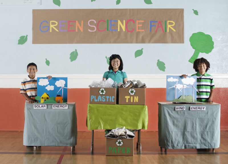 School,USA,Three students standing by their project displays at a Green Science Fair event.