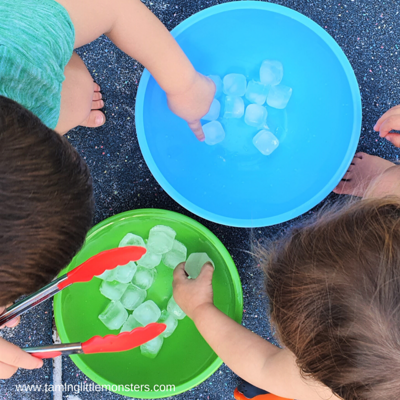 ice-transfer child hands holding a tong and ice cubes