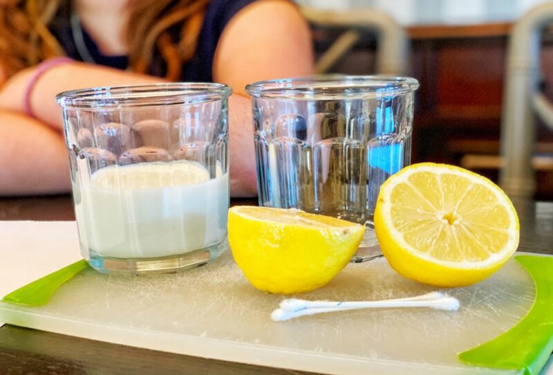 invisible-ink A glass of milk, a glass of water, a sliced lemon and a qtip laid out on a table