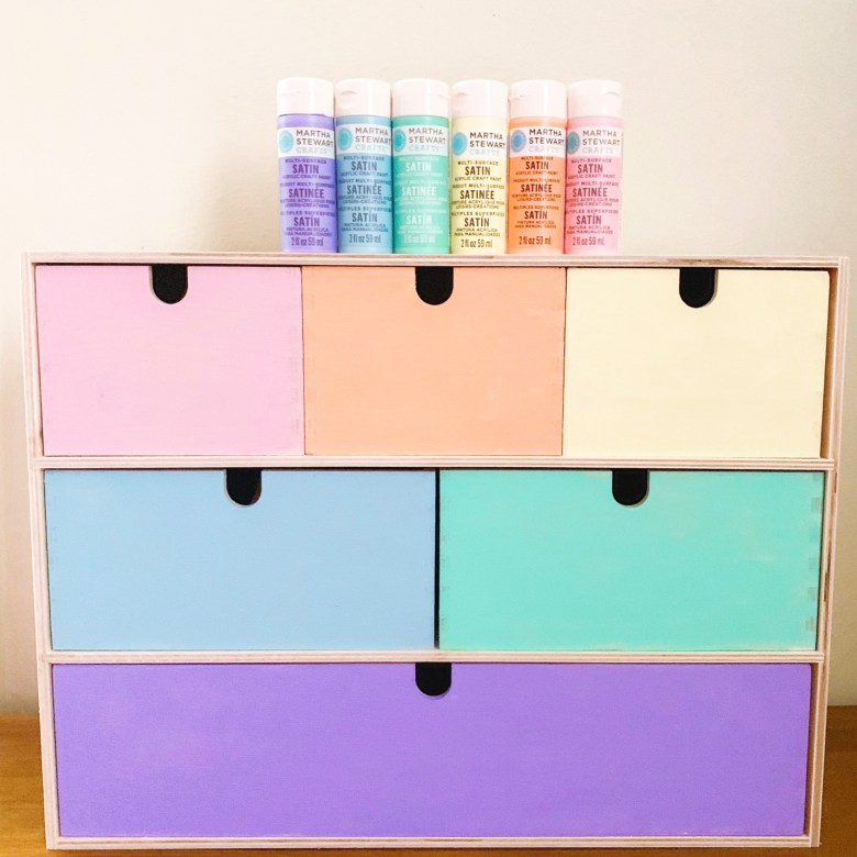 Ikea classroom ideas: A chest of draws is painted in pastel colors with tubes of paint sitting on the top of it.