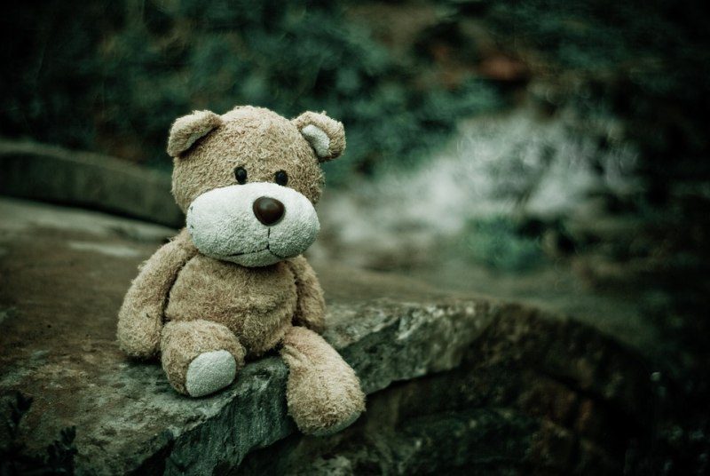 Picture Writing Prompts: Teddy Bear Worn teddy bear sitting on a stone bridge