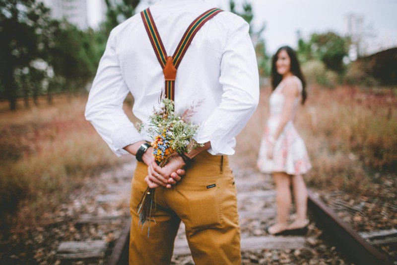 Picture Writing Prompts: Question Figure holding flowers behind its back, with a woman turning to look in the background
