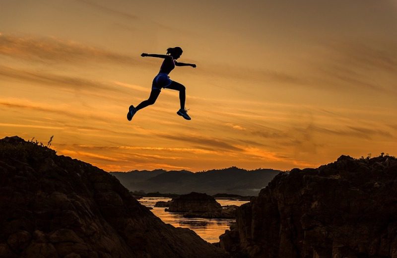 Picture Writing Prompts: Jump Woman leaping across a chasm silhouetted by an orange sky