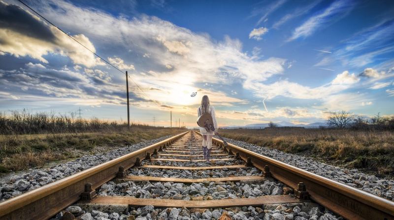 Picture Writing Prompts: Rail Girl Woman standing on railroad tracks holding a guitar and looking off into the distant sunset (Picture Writing Prompts)