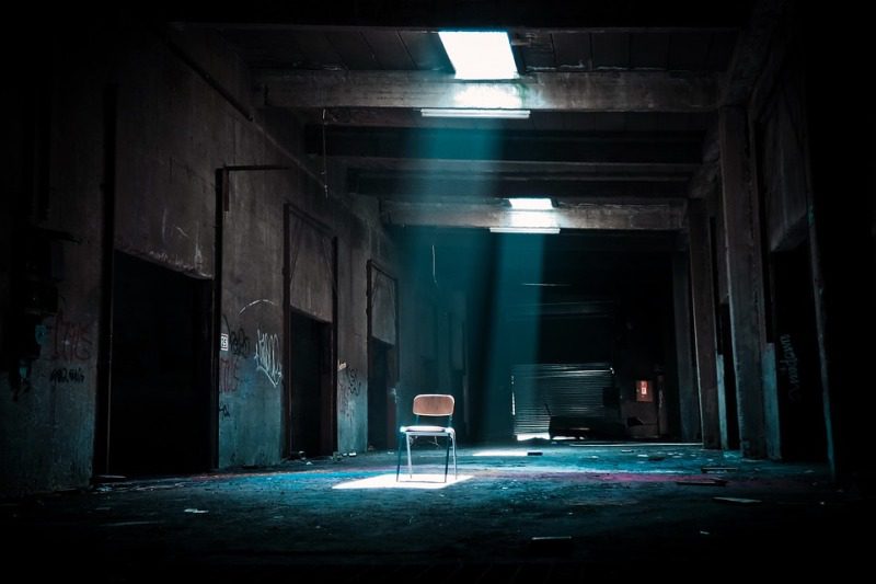 Picture Writing Prompts: Empty Hallway A chair sits in the hallway of an abandoned building under a shaft of light from above (High School Picture Writing Prompts)