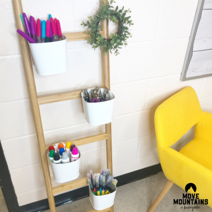 Ikea classroom ideas: A ladder like plant stand is shown with white cups attached that are filled with art supplies.