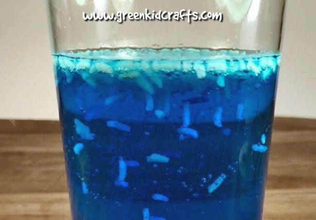 dancing-rice Glass of blue liquid with rice floating and moving in it