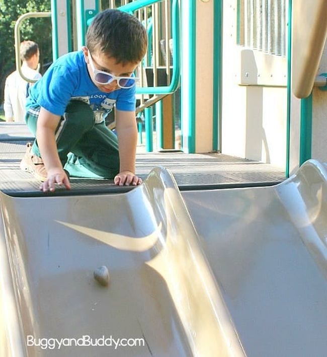 gravity-and-friction Preschool science student sending a rock down a playground slide