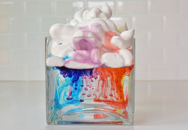 shaving-cream-rain-clouds Square glass vase filled with water with shaving cream floating on top. Food coloring is dripping down through the cream into the water.