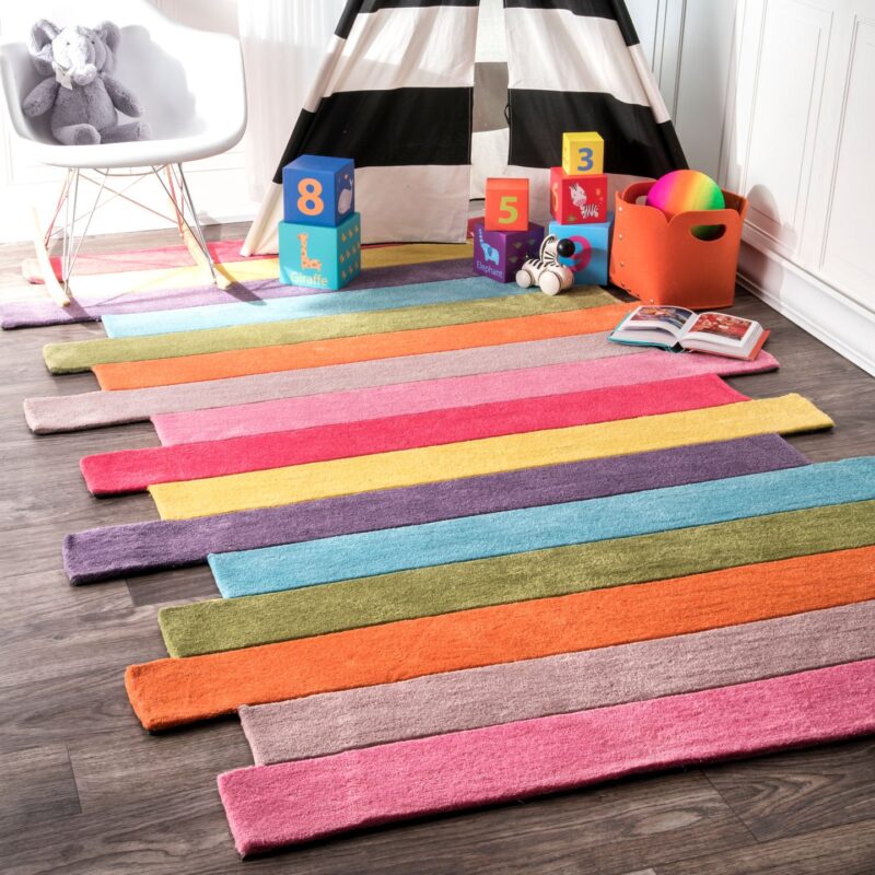 Rainbow Rug A rug is made up of different colored stripes. The edges are jagged.