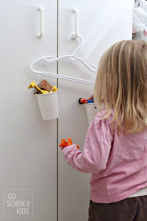 hanger-scale A little girl hanging a cup on a homemade scale made from a plastic clothes hanger