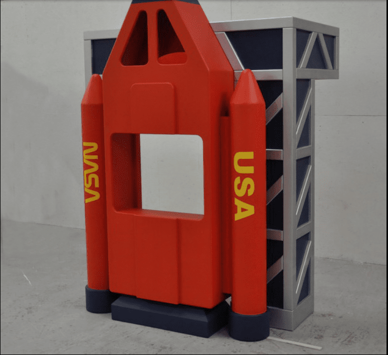 Upright red space shuttle reading nook that says, "NASA" and "USA"
