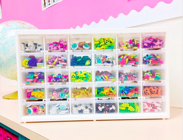 A clear plastic bin filled with tiny erasers
