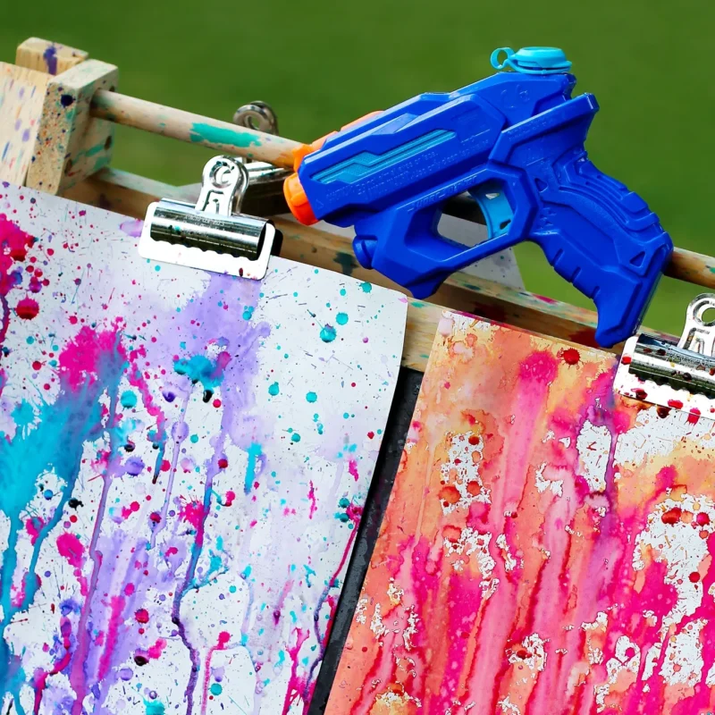 squirt-gun-painting squirt gun and papers with paint