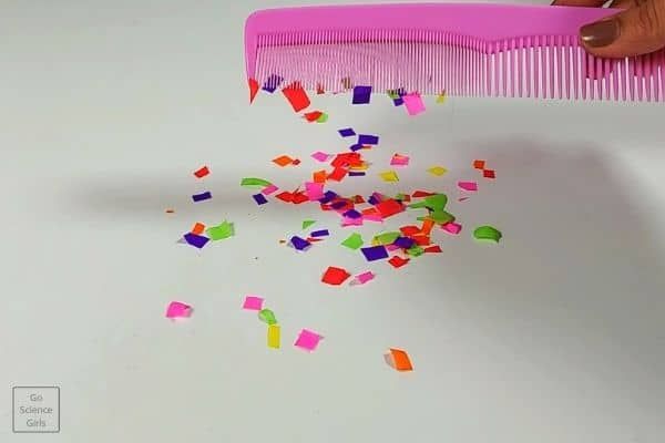 static-electricity A pink plastic comb attracts pieces of confetti through static electricity as an example of science activities for preschoolers