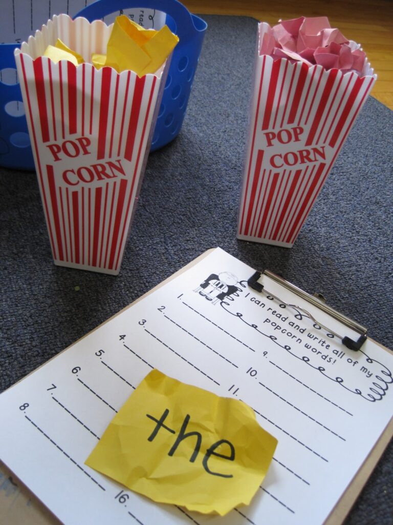 The Big List of Dollar Store Hacks for Teachers Red and white striped popcorn boxes with crumpled up paper inside of them next to a clipboard with a worksheet and the word "the" on a piece of yellow construction paper