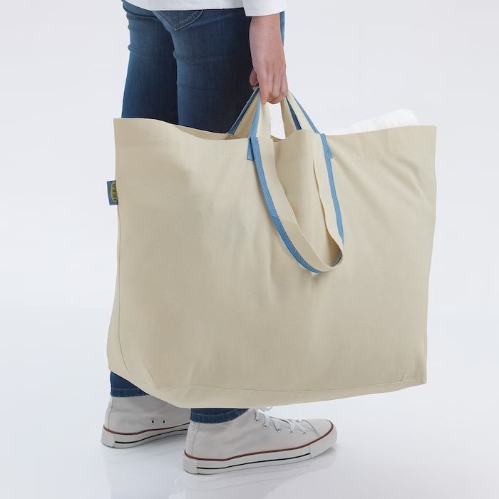 Tote Bag A woman is shown from the waist down holding a tote bag.