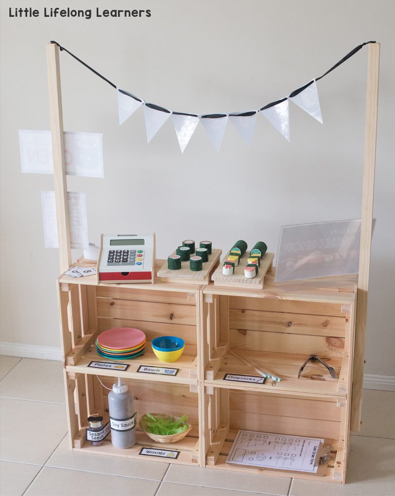 Ikea classroom ideas: Four wooden crates are assembled to form a toy farm stand. A cash register and some fake food are included.